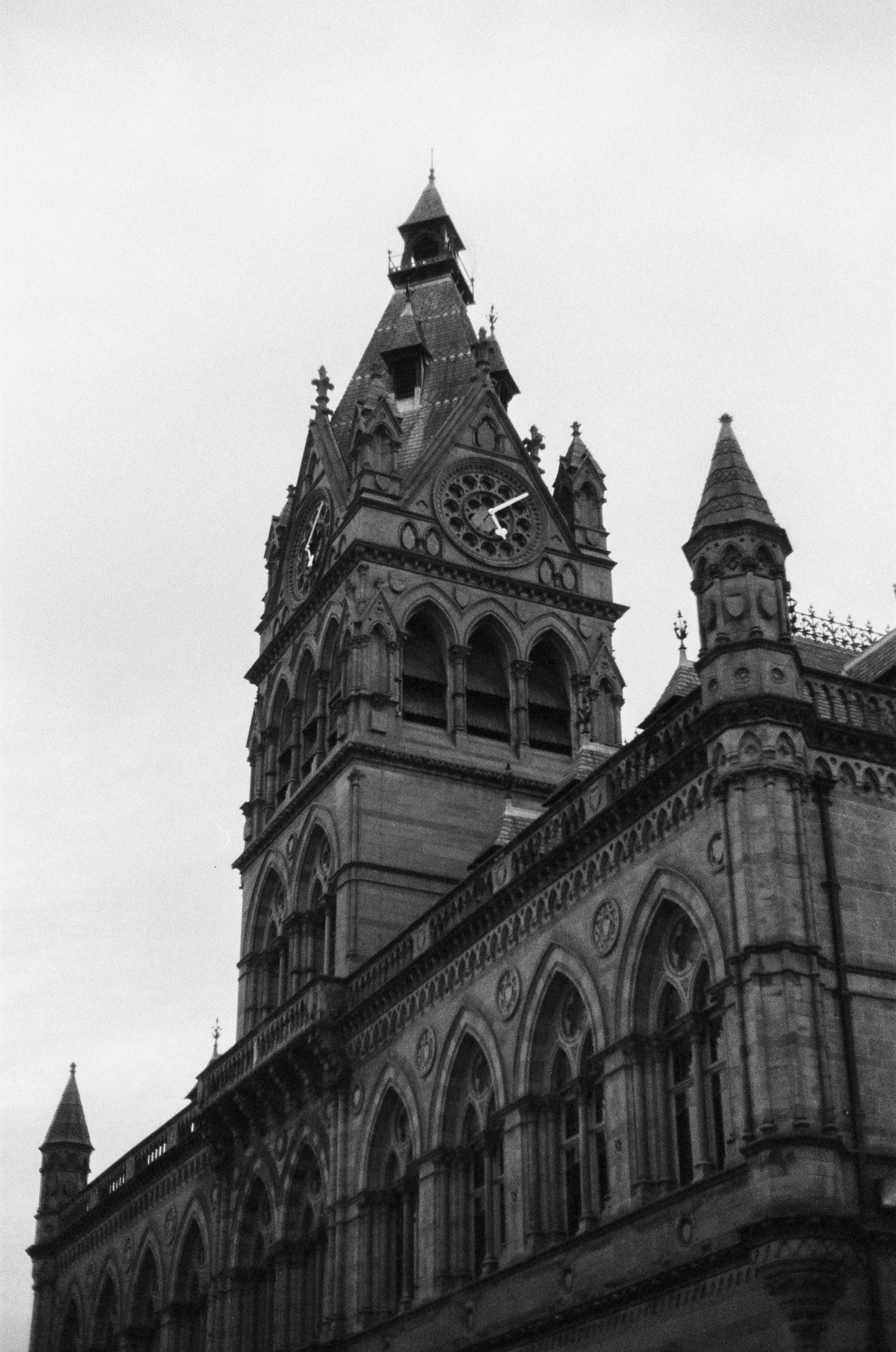 Low-angle view of a historic stone building featuring an ornate clock tower with arched windows.